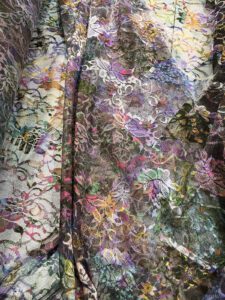 Šarena elastična čipka nežne teksture, u toplim i zemljanim bojama koje podsećaju na festivalske dane, umetničke duše i šetnje po letnjim pijacama…