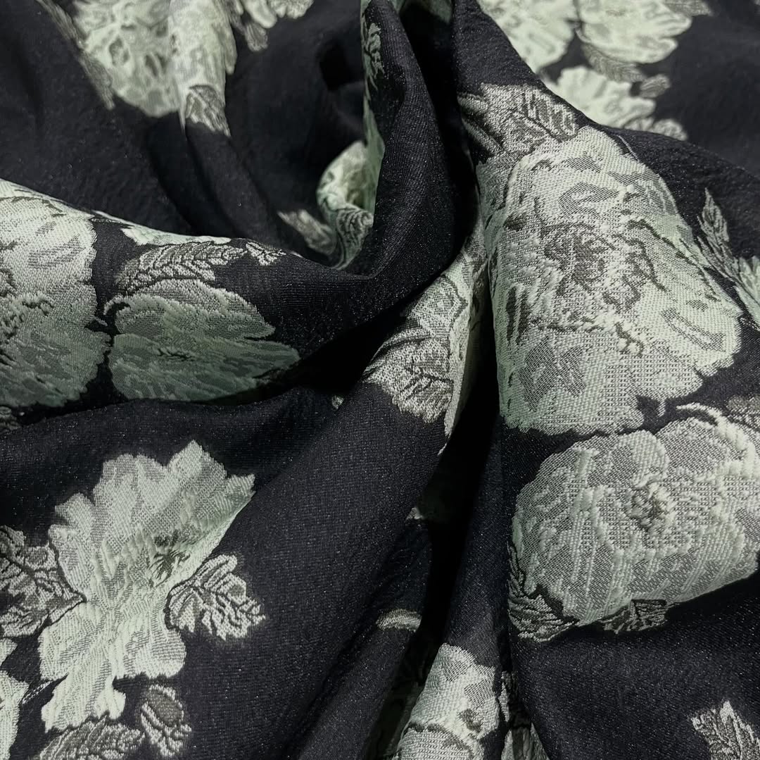 Elegantni brokat sa reljefnim cvetovima u zelenkastim tonovima na crnoj osnovi
